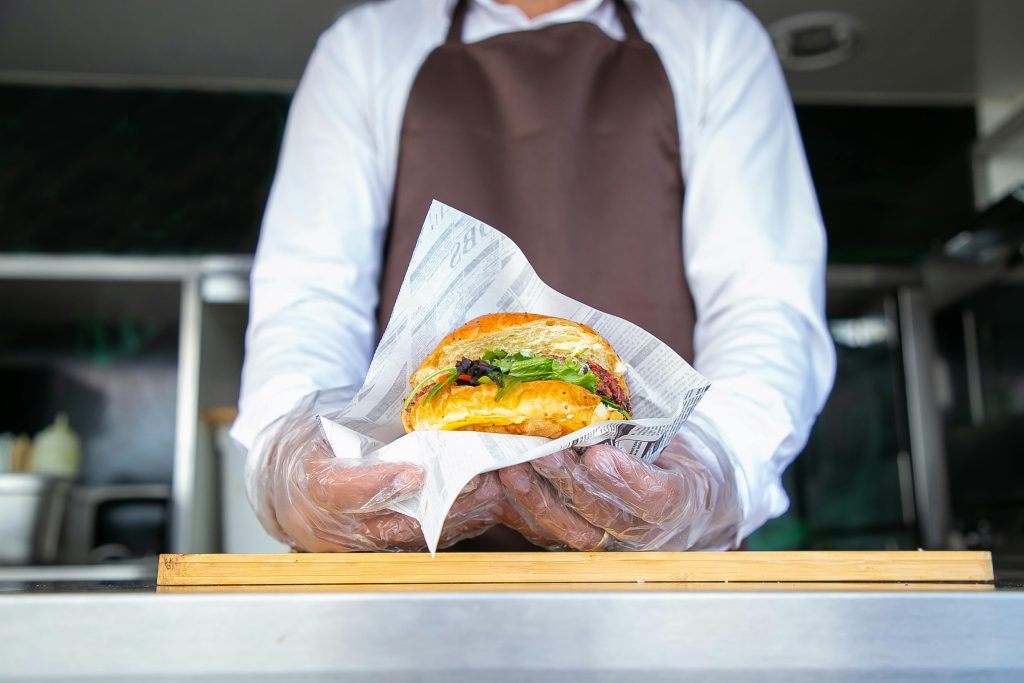 Imatge d'un cuiner agafant una hamburguesa