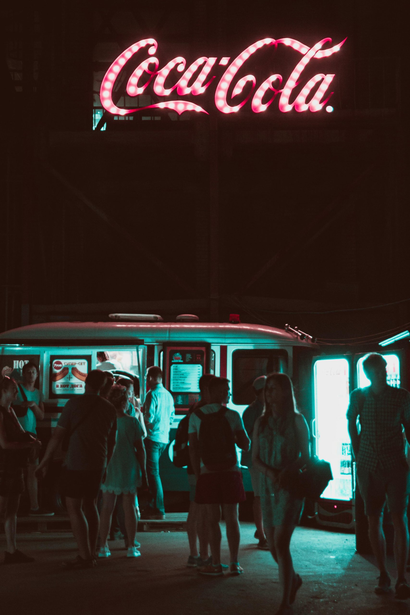 Imatge de nit d'una food truck, gent i un cartell de Coca·Cola 